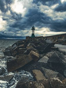 Preview wallpaper lighthouse, sea, coast, stones, clouds