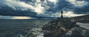 Preview wallpaper lighthouse, sea, coast, stones, clouds