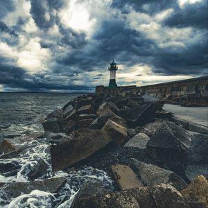 Preview wallpaper lighthouse, sea, coast, stones, clouds