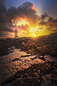 Preview wallpaper lighthouse, stones, shore, clouds