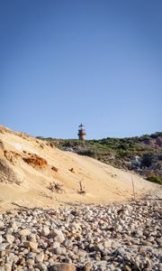 Preview wallpaper lighthouse, stones, slope, sky
