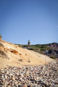 Preview wallpaper lighthouse, stones, slope, sky