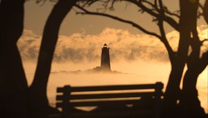 Preview wallpaper lighthouse, sunset, bench, blur, trees, branches