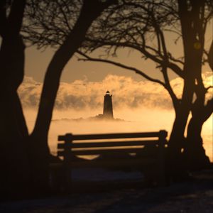 Preview wallpaper lighthouse, sunset, bench, blur, trees, branches