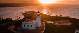 Preview wallpaper lighthouse, tower, building, pier, water, horizon, sunset