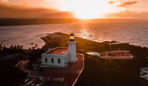 Preview wallpaper lighthouse, tower, building, pier, water, horizon, sunset