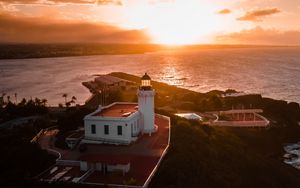 Preview wallpaper lighthouse, tower, building, pier, water, horizon, sunset