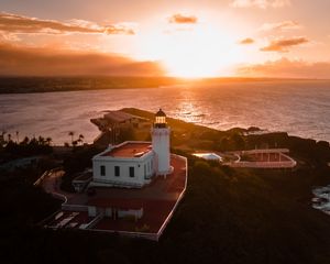 Preview wallpaper lighthouse, tower, building, pier, water, horizon, sunset