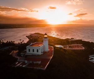 Preview wallpaper lighthouse, tower, building, pier, water, horizon, sunset