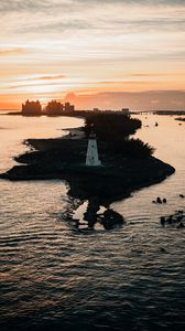 Preview wallpaper lighthouse, tower, island, sea, buildings, sunset