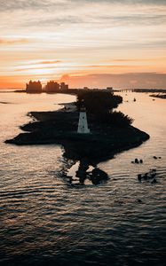Preview wallpaper lighthouse, tower, island, sea, buildings, sunset