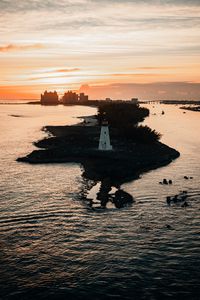 Preview wallpaper lighthouse, tower, island, sea, buildings, sunset