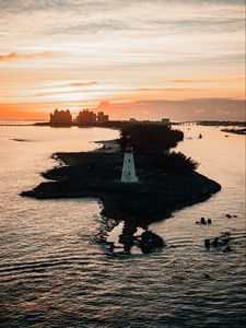 Preview wallpaper lighthouse, tower, island, sea, buildings, sunset