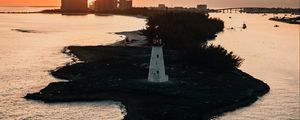 Preview wallpaper lighthouse, tower, island, sea, buildings, sunset