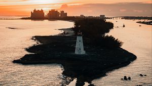Preview wallpaper lighthouse, tower, island, sea, buildings, sunset