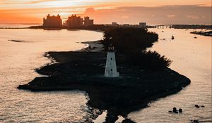 Preview wallpaper lighthouse, tower, island, sea, buildings, sunset