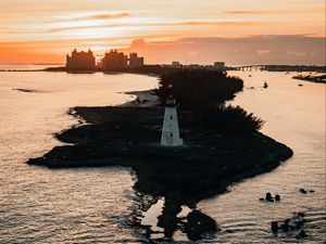 Preview wallpaper lighthouse, tower, island, sea, buildings, sunset