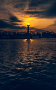 Preview wallpaper lighthouse, tower, light, water, trees, twilight, dark