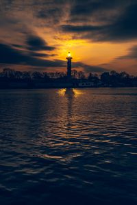 Preview wallpaper lighthouse, tower, light, water, trees, twilight, dark
