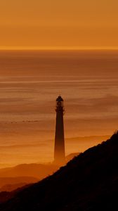 Preview wallpaper lighthouse, tower, sea, mountains, sunset, dark
