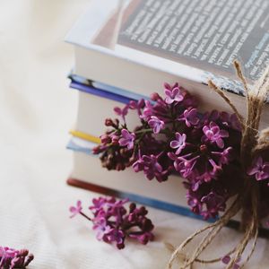 Preview wallpaper lilac, flowers, books, reading, aesthetics