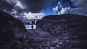 Preview wallpaper loneliness, rocks, man, shore, sea, stones