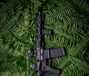 Preview wallpaper machine gun, weapon, black, fern, leaves