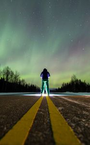 Preview wallpaper man, alone, backlight, road, northern lights