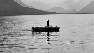 Preview wallpaper man, alone, boat, lake, black and white