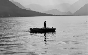 Preview wallpaper man, alone, boat, lake, black and white