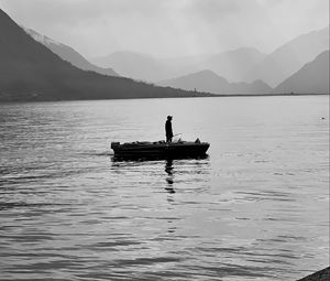 Preview wallpaper man, alone, boat, lake, black and white