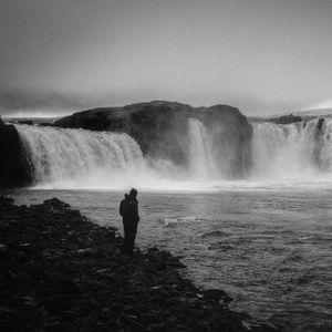 Preview wallpaper man, alone, bw, waterfall, nature