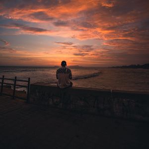 Preview wallpaper man, alone, embankment, water, sunset