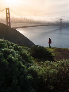 Preview wallpaper man, alone, hill, river, bridge, fog