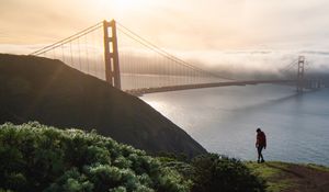 Preview wallpaper man, alone, hill, river, bridge, fog