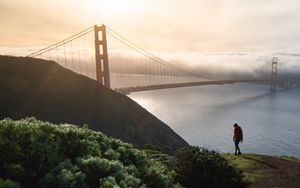 Preview wallpaper man, alone, hill, river, bridge, fog