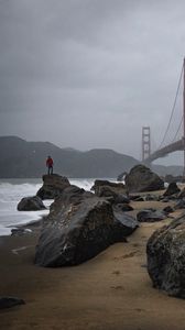 Preview wallpaper man, alone, rocks, waves, shore, bridge