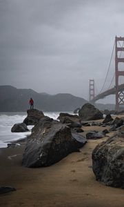 Preview wallpaper man, alone, rocks, waves, shore, bridge