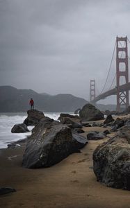 Preview wallpaper man, alone, rocks, waves, shore, bridge