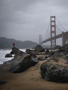 Preview wallpaper man, alone, rocks, waves, shore, bridge