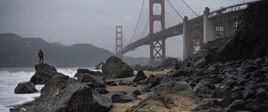 Preview wallpaper man, alone, rocks, waves, shore, bridge