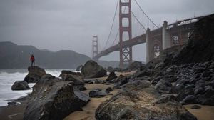 Preview wallpaper man, alone, rocks, waves, shore, bridge