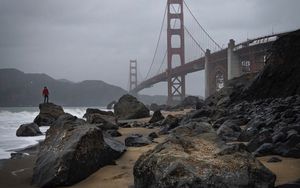 Preview wallpaper man, alone, rocks, waves, shore, bridge