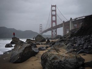 Preview wallpaper man, alone, rocks, waves, shore, bridge