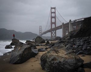 Preview wallpaper man, alone, rocks, waves, shore, bridge