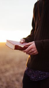 Preview wallpaper man, book, field, sunlight