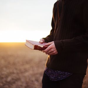 Preview wallpaper man, book, field, sunlight