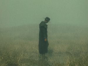 Preview wallpaper man, cloak, hat, field, fog, dark, art