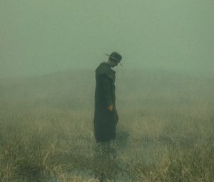 Preview wallpaper man, cloak, hat, field, fog, dark, art