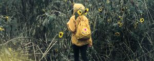 Preview wallpaper man, field, flowers, backpack, clouds, overcast